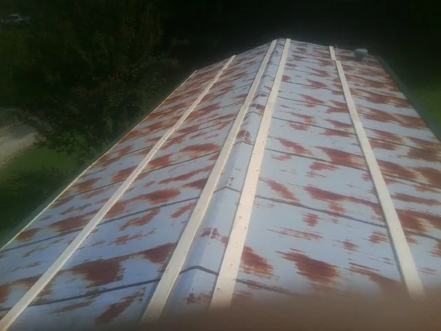 Rusted metal roof panels with new wood purlins before replacement — Storm Damage Roof Repair in Guntown by Roofing Brothers