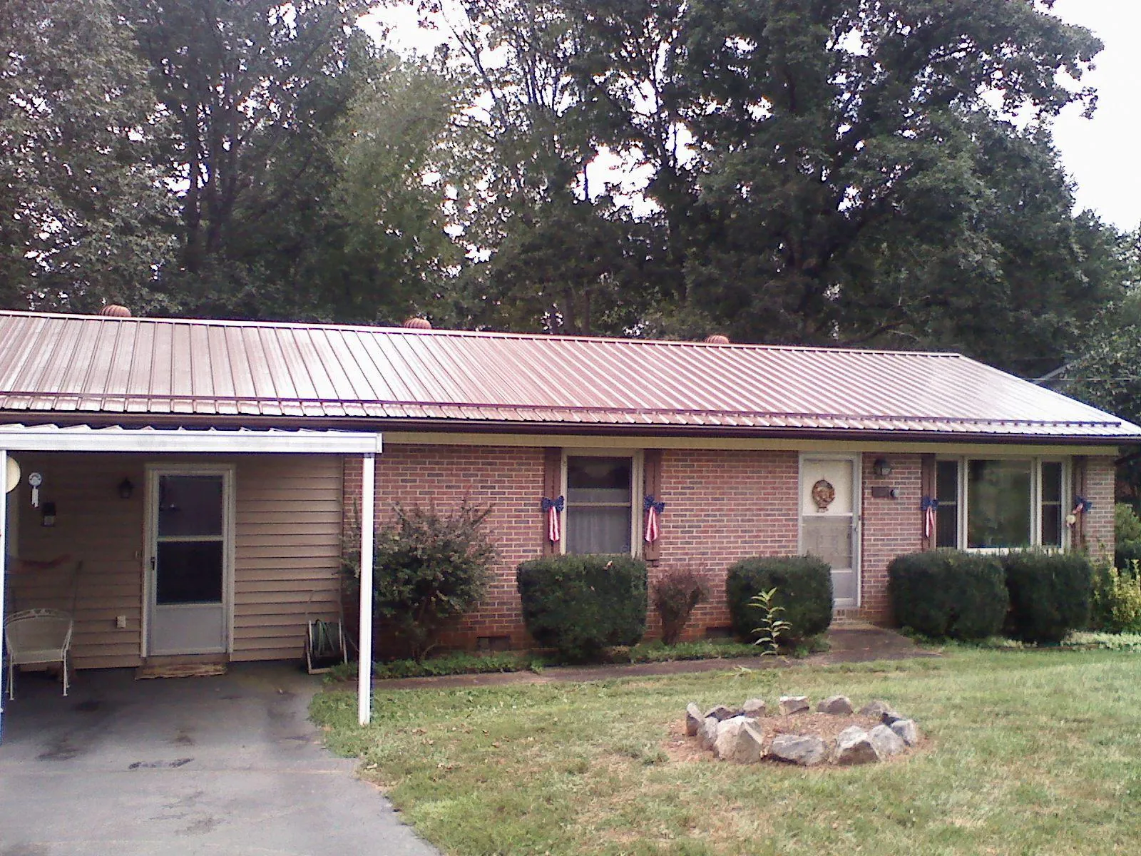 Bronze metal roof and carport on a brick ranch home — Roof Repair work by our crew in Guntown