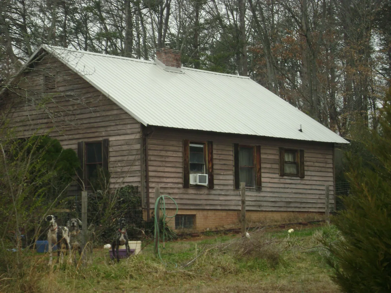 White metal roof on an old wood sided farmhouse, from a Metal Roof Installation job in Guntown